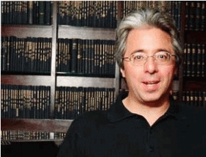 Photo of John Albanese with full bookcase in background